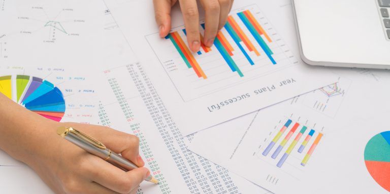 Business woman hand with Financial charts and laptop on the ta